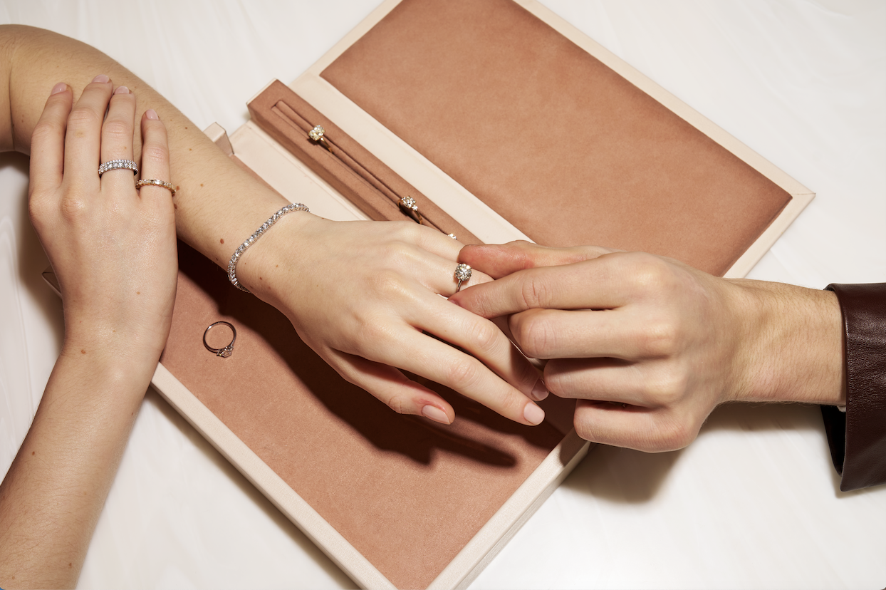 A person putting an engagement ring on a woman's finger